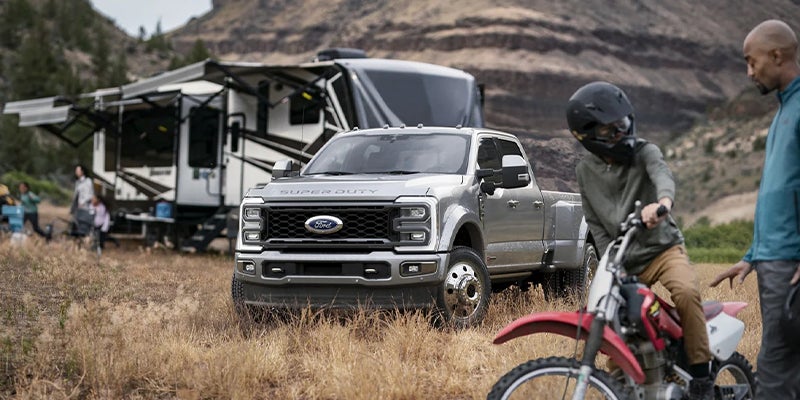 Super Duty parked at a campsite beside a family with outdoor gear