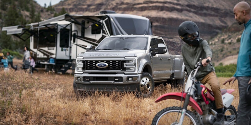 Ford Super Duty towing a trailer loaded with motorcycles in a scenic area