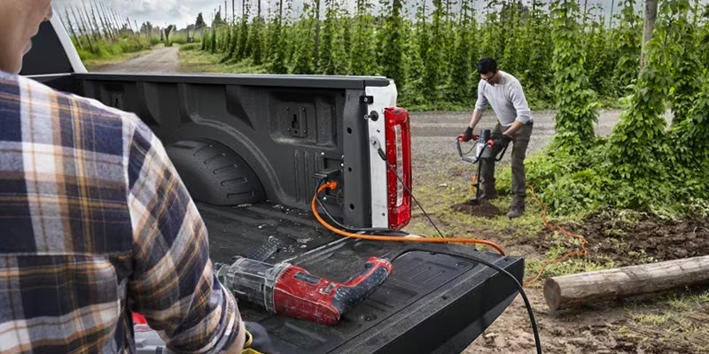 Man using built-in tailgate functionality with tools loaded